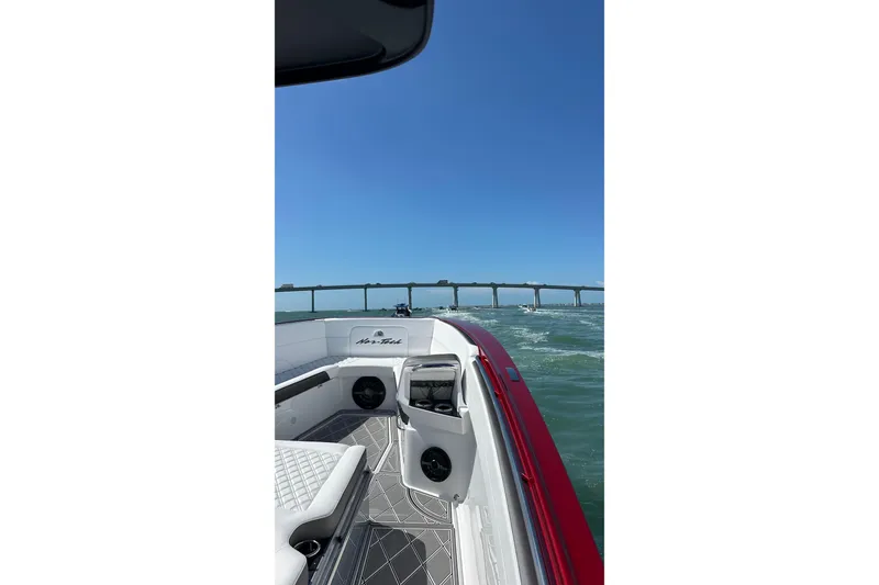 Slide: The Image of 2025 Nor-Tech 390 Sport boat cruising under a bridge on a sunny day. - 15