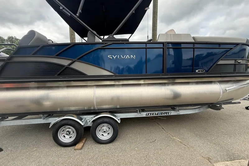 The Image of 2026 Sylvan L-3 RLZ DH pontoon boat on trailer, blue and silver design. - 1