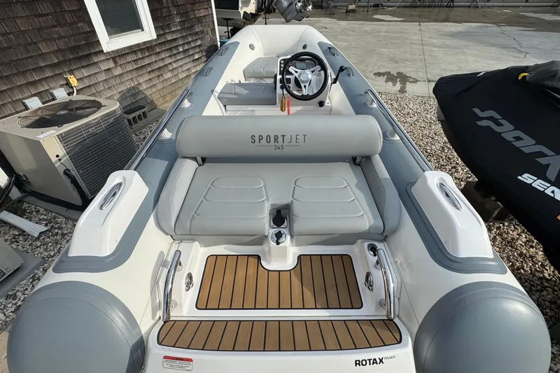 Slide: The Image of 2024 Williams Jet Tenders Sportjet 345, sleek design, luxury seating, and modern steering wheel. - 4