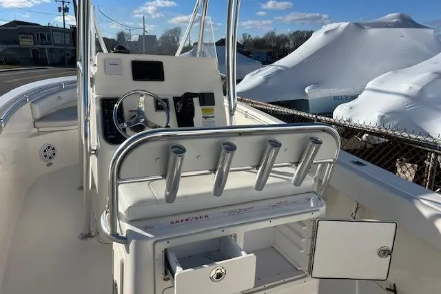 Slide: The Image of 2020 Cobia 237 Center Console boat with steering wheel and rod holders, docked outdoors. - 10