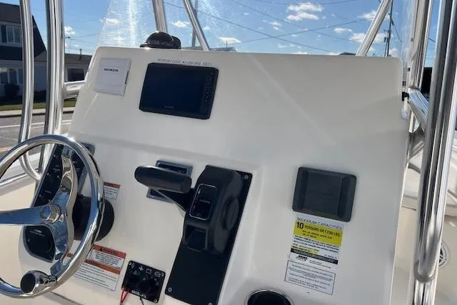 Slide: The Image of 2020 Cobia 237 Center Console boat dashboard with steering wheel and navigation controls. - 11
