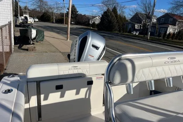 Slide: The Image of 2020 Cobia 237 Center Console boat parked on a street, showcasing seating and engine. - 12
