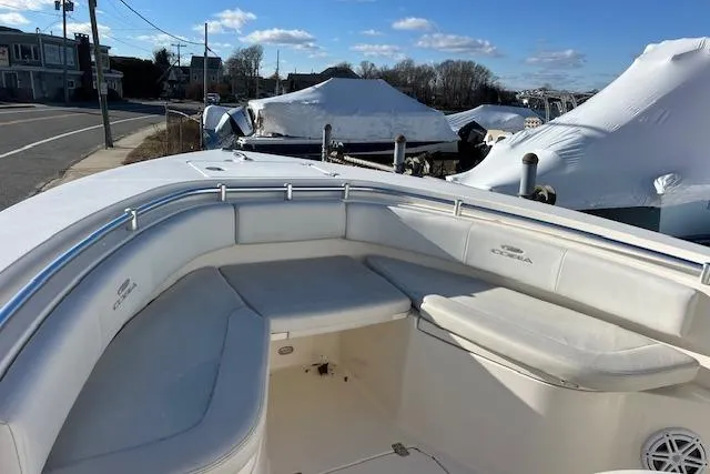 Slide: The Image of 2020 Cobia 237 Center Console boat with cushioned seating, docked under clear skies. - 15