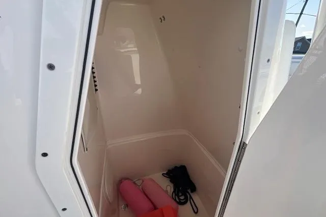Slide: The Image of 2020 Cobia 237 Center Console storage compartment with life jackets and ropes. - 9