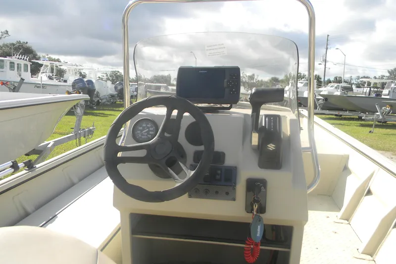 Slide: The Image of Close-up of a 2023 SeaArk 1660 c/c boat engine in a marina setting. - 2