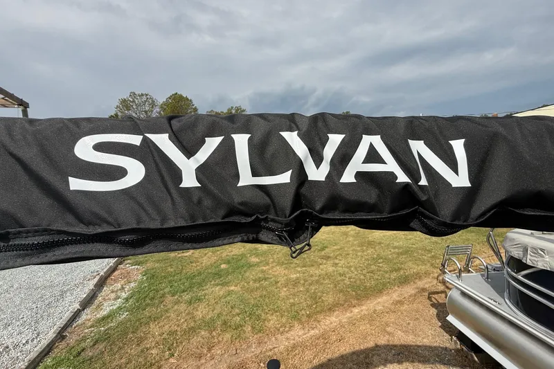 Slide: The Image of Sylvan X-1 CLZ DH 2026 boat cover with logo, outdoor setting. - 30