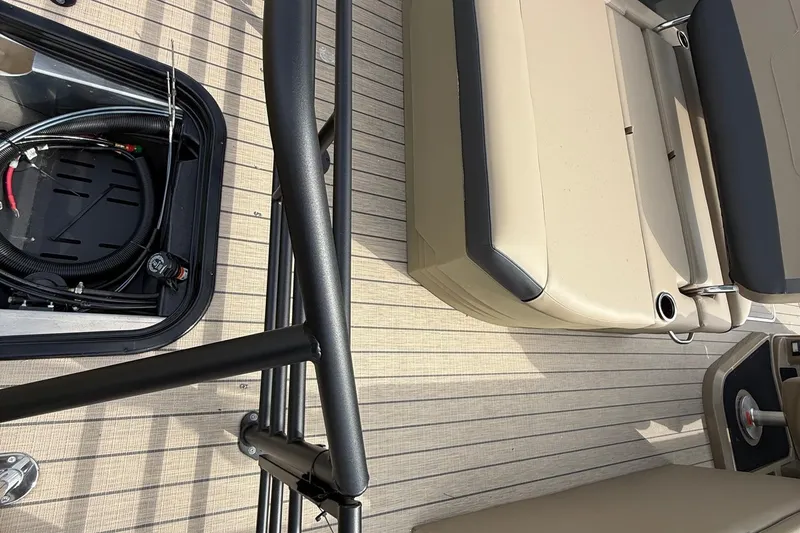 Slide: The Image of 2026 Sylvan X-1 CLZ DH boat interior with beige seating and open storage compartment. - 8