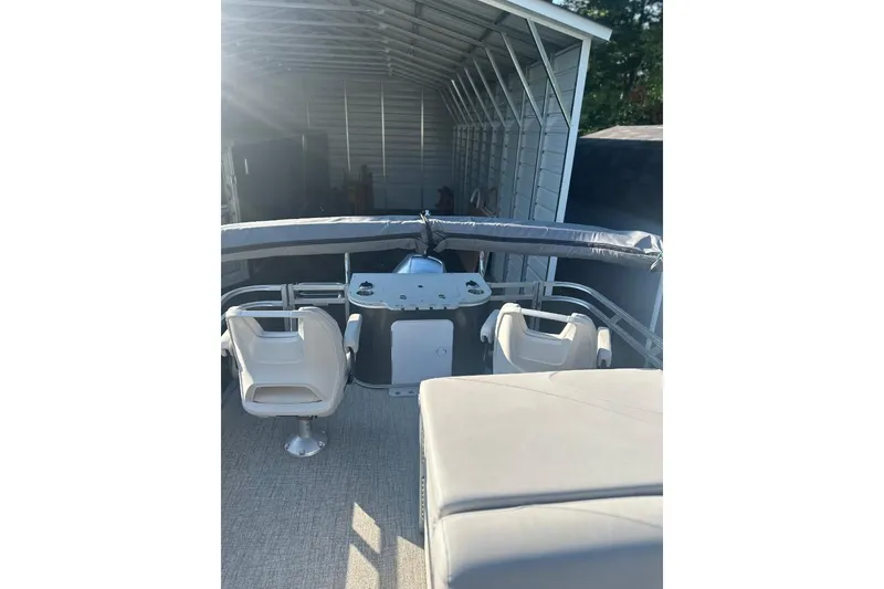 Slide: The Image of 2022 Avalon GS 2385 RF boat interior with seating, stored in a covered area. - 4