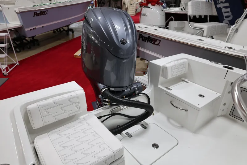 Slide: The Image of 2026 Parker 180 Coastal boat with outboard motor, white seating, and red carpet display. - 10