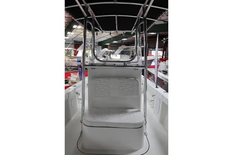 Slide: The Image of 2026 Parker 180 Coastal boat interior with seating and canopy in showroom. - 16