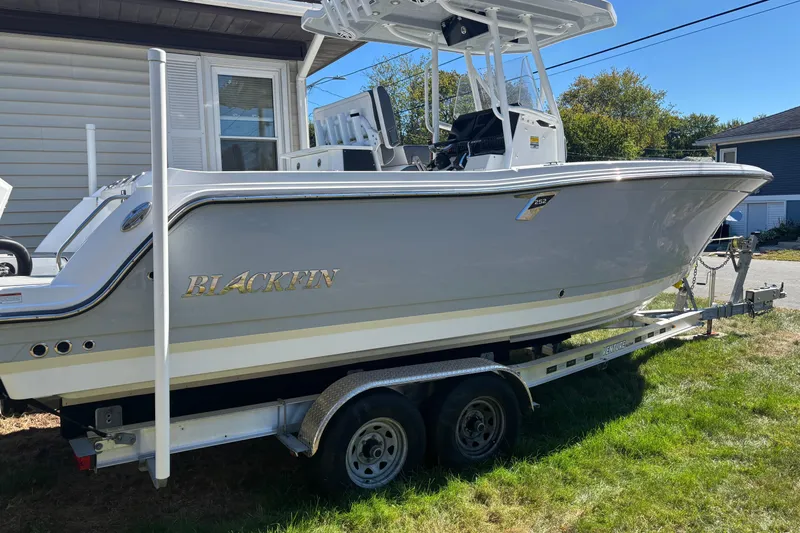 The Image of 2022 Blackfin 252 CC boat on trailer, parked beside a house. - 1