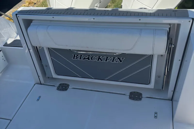 Slide: The Image of 2022 Blackfin 252 CC boat seat with logo and storage compartment. - 12