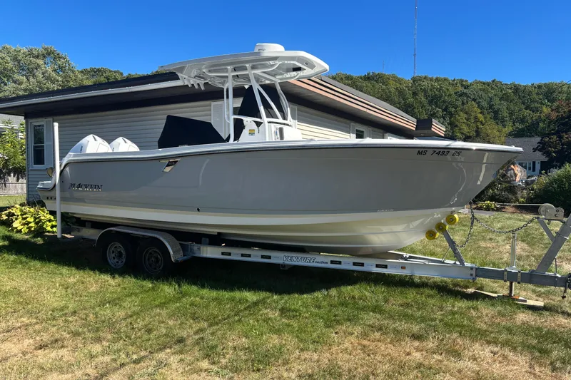 Slide: The Image of 2022 Blackfin 252 CC boat on trailer, parked beside a house. - 2