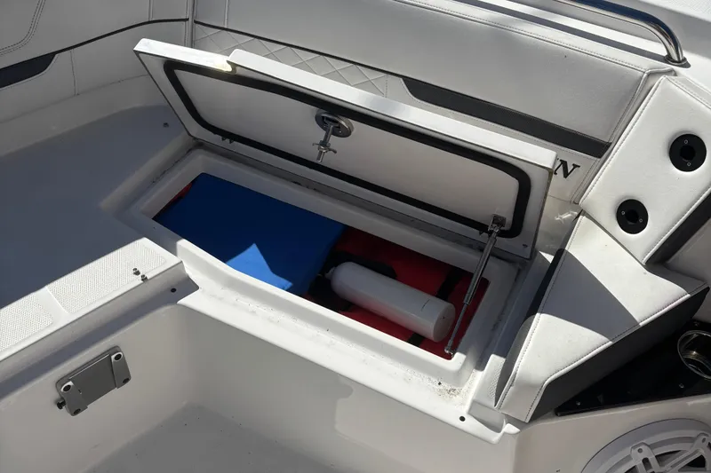 Slide: The Image of Open storage compartment on 2022 Blackfin 252 CC boat, showing interior items. - 21