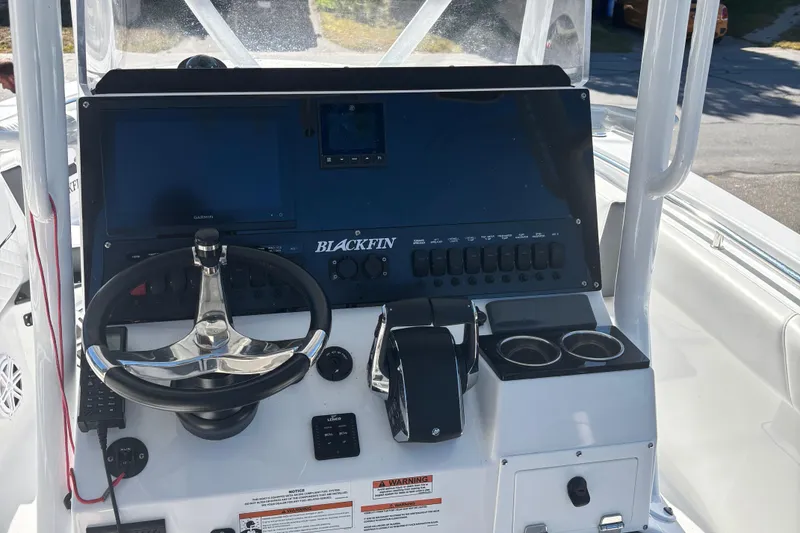 Slide: The Image of 2022 Blackfin 252 CC boat dashboard with steering wheel and control panel. - 24