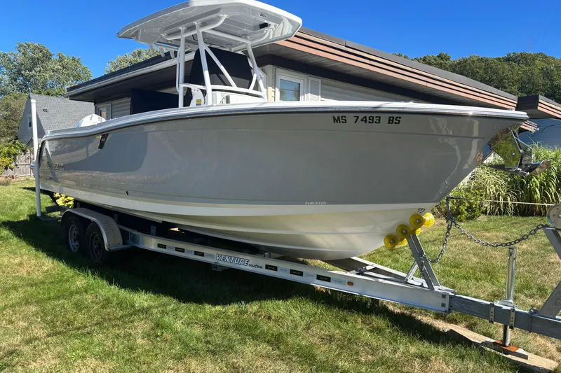 Slide: The Image of 2022 Blackfin 252 CC boat on trailer, parked in a grassy yard. - 3