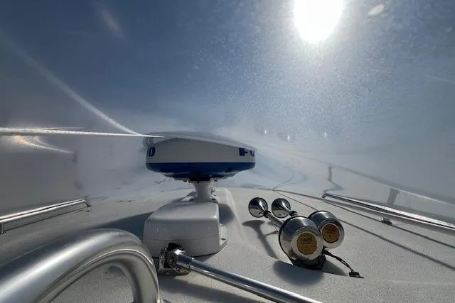 Slide: The Image of 2023 Parker 2820 XLD Sport Cabin boat under protective cover, sunlight filtering through. - 21