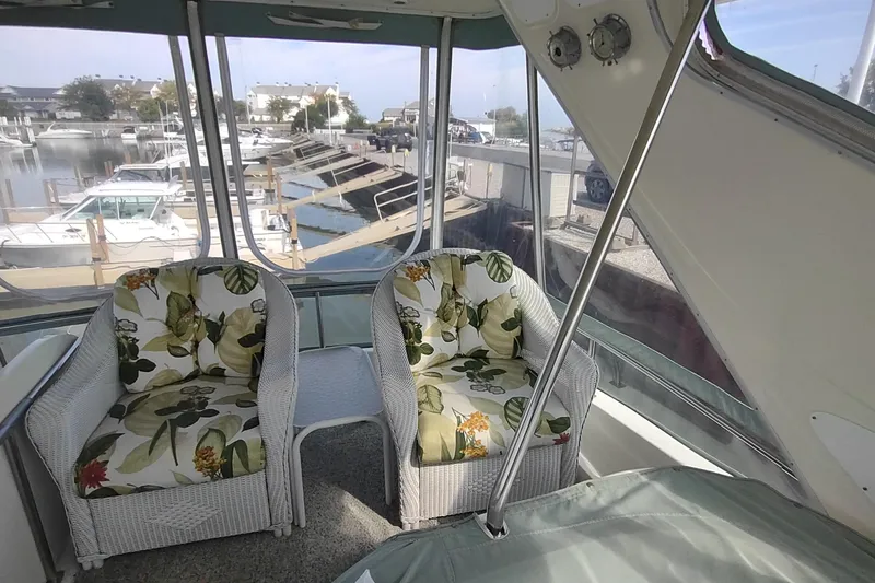 Slide: The Image of Interior of 2001 Maxum 4600 SCB yacht with floral cushioned wicker chairs. - 11