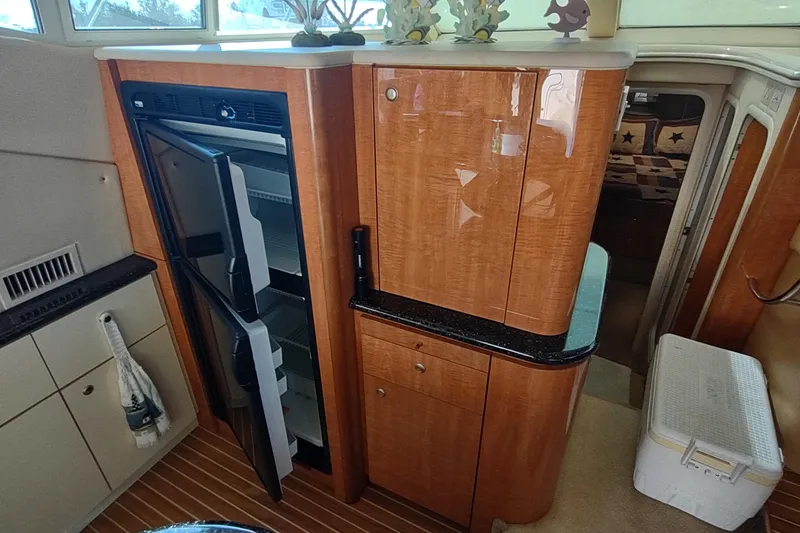 Slide: The Image of 2001 Maxum 4600 SCB yacht interior with open fridge and wooden cabinetry. - 23