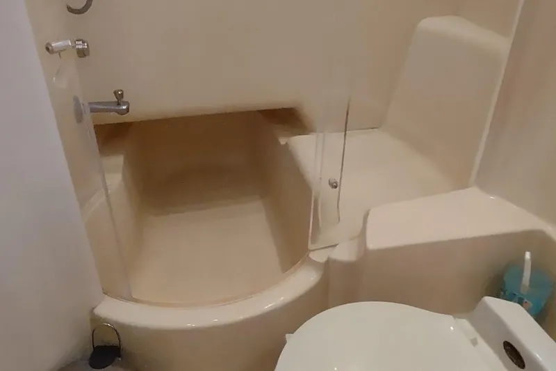 Slide: The Image of Bathroom interior of 2001 Maxum 4600 SCB yacht, featuring a compact shower and toilet. - 38