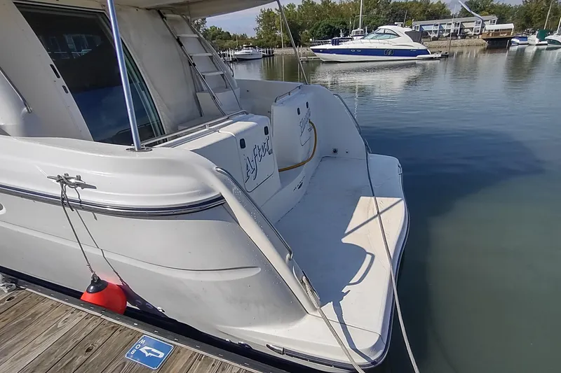 Slide: The Image of 2001 Maxum 4600 SCB yacht docked at marina, rear view with water reflection. - 9