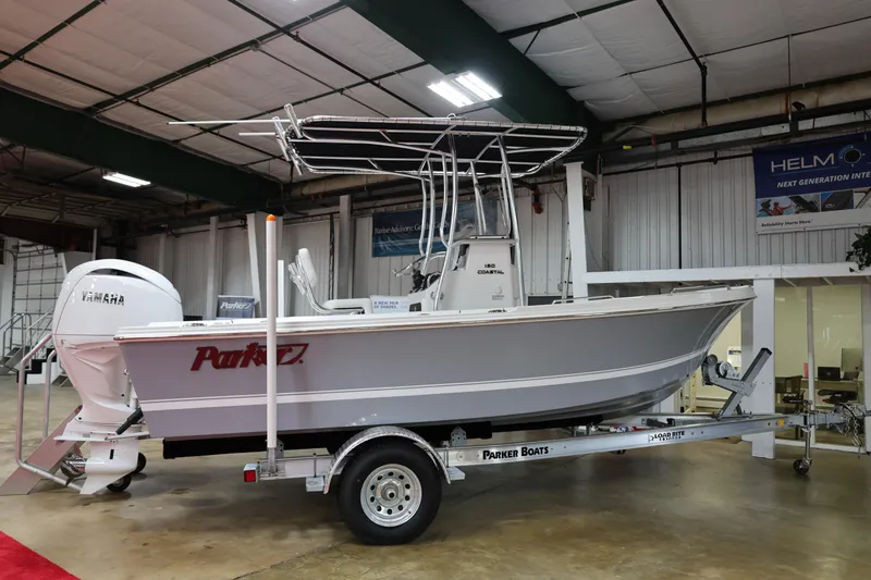 The Image of 2026 Parker 180 Coastal boat on trailer in showroom, featuring Yamaha engine. - 1