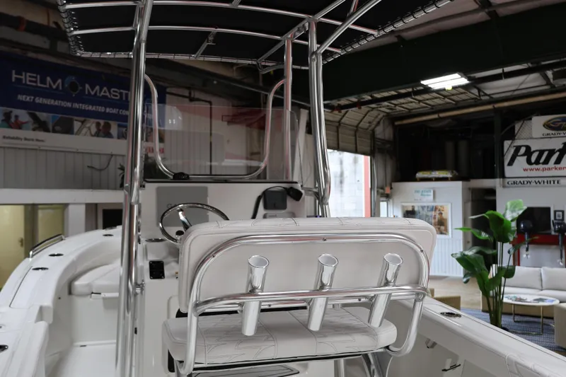 Slide: The Image of 2026 Parker 180 Coastal boat interior with rod holders and steering console in showroom. - 4