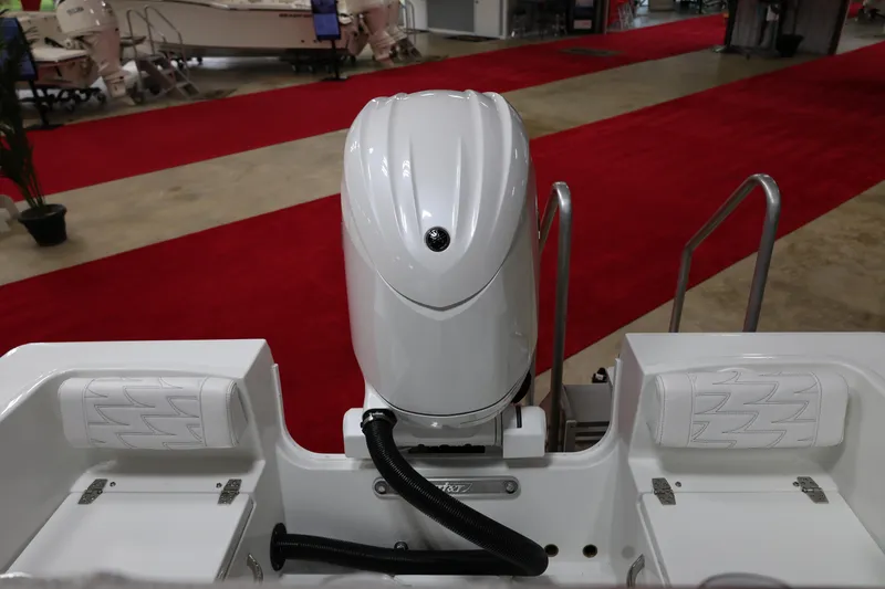 Slide: The Image of 2026 Parker 180 Coastal boat with outboard motor, displayed on red carpet at a show. - 5