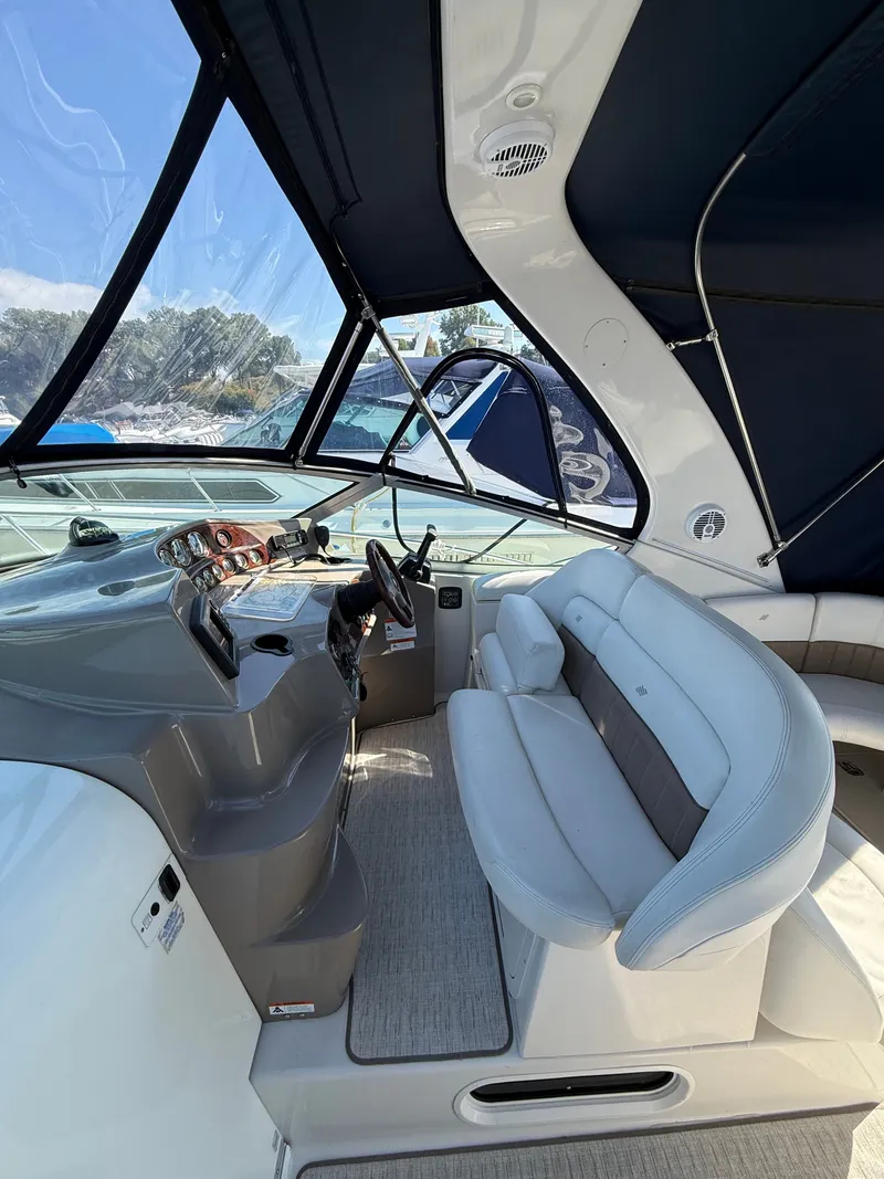 Slide: The Image of Interior of a 2004 Four 328 Vista boat with steering wheel and seating area. - 12