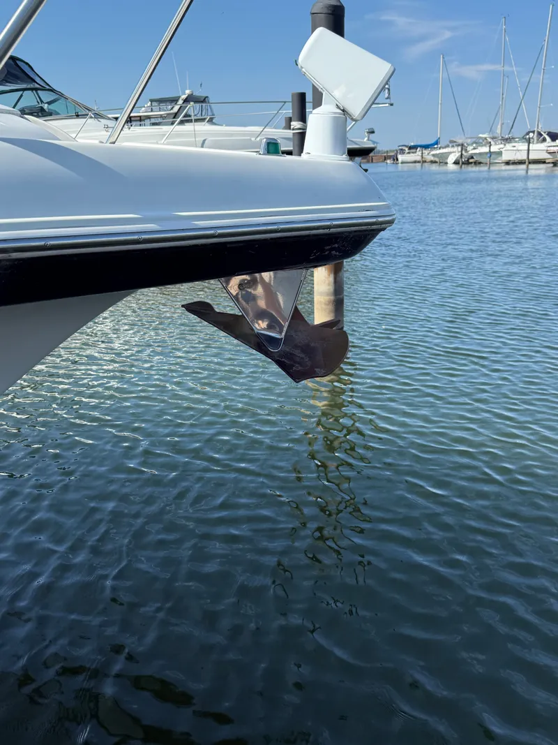 Slide: The Image of 2004 Four 328 Vista boat with anchor in marina, calm water, clear sky. - 19