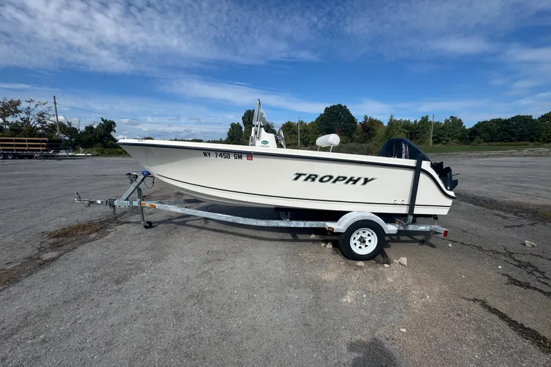 Slide: The Image of 2007 Trophy 1703 Center Console boat on trailer, parked outdoors under blue sky. - 0
