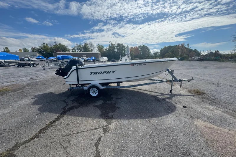 Slide: The Image of 2007 Trophy 1703 Center Console boat on trailer in parking lot under cloudy sky. - 2