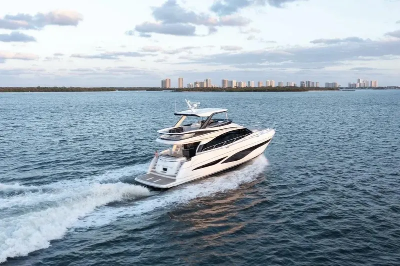 Slide: The Image of Luxurious 2026 Princess F65 yacht cruising on open water with city skyline backdrop. - 2