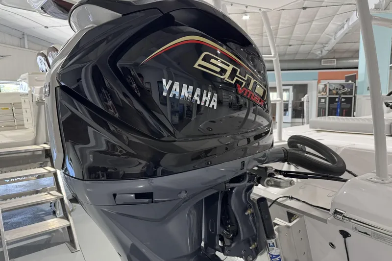 Slide: The Image of 2026 Action Craft 20 Flatsmaster boat, sleek white hull with chrome logo in a showroom. - 6