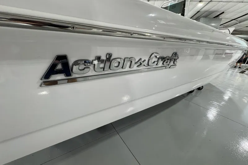 Slide: The Image of 2026 Action Craft 20 Flatsmaster boat displayed indoors on a wheeled stand. - 3