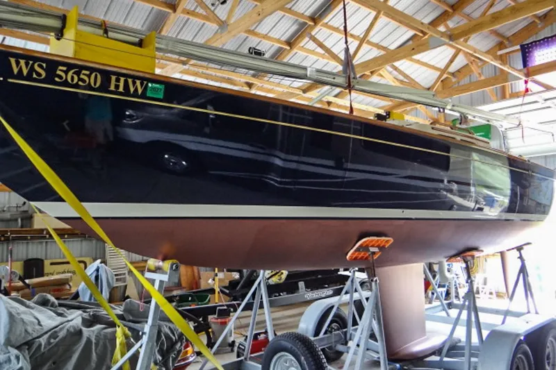 Slide: The Image of 2012 Morris Yachts M29 sailboat in a wooden boathouse, supported by a trailer. - 10