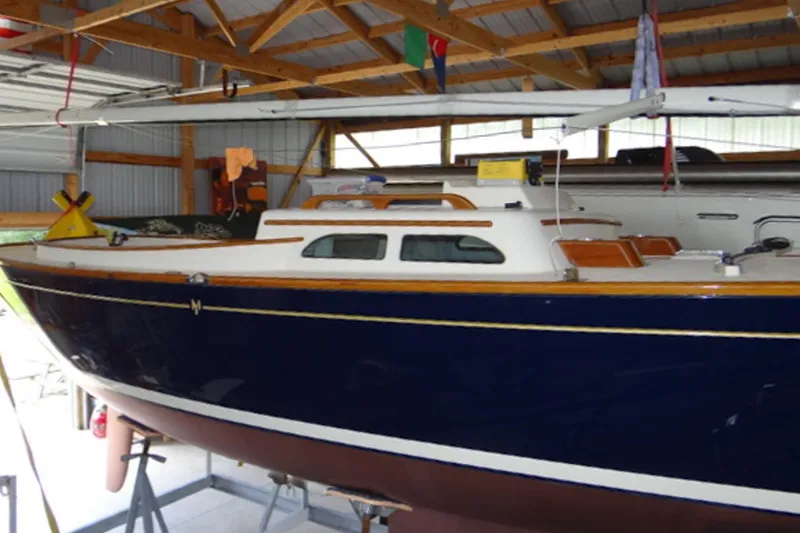 Slide: The Image of 2012 Morris Yachts M29 sailboat in a wooden boathouse, showcasing sleek design. - 12