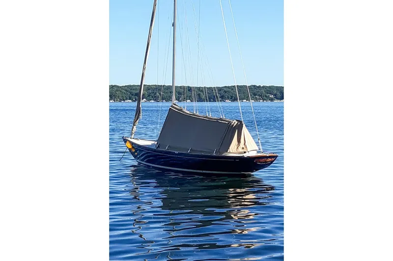 Slide: The Image of 2012 Morris Yachts M29 sailboat on calm water, covered, with scenic shoreline background. - 16