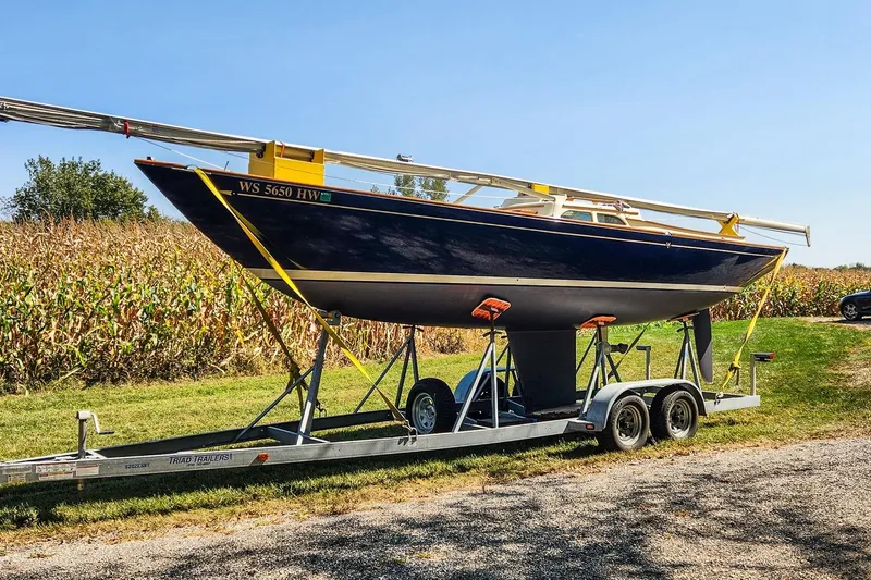 Slide: The Image of 2012 Morris Yachts M29 sailboat on trailer, parked near cornfield under clear blue sky. - 3
