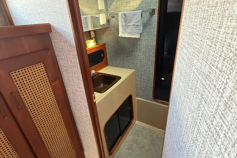 Slide: The Image of 1983 Bayliner 3870 Motoryacht bathroom with sink, towel rack, and wooden cabinetry. - 11
