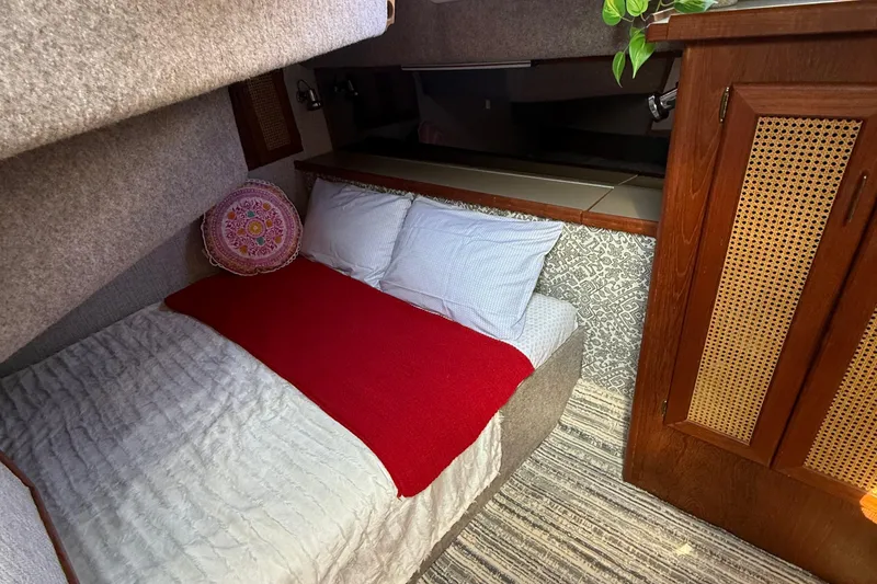 Slide: The Image of Cozy bedroom in 1983 Bayliner 3870 Motoryacht with red blanket and decorative pillow. - 13