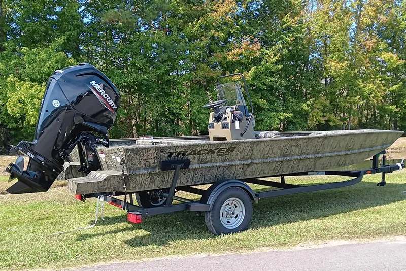 Slide: The Image of 2026 Tracker Grizzly 1860 CC boat with Mercury engine on trailer, outdoors. - 2