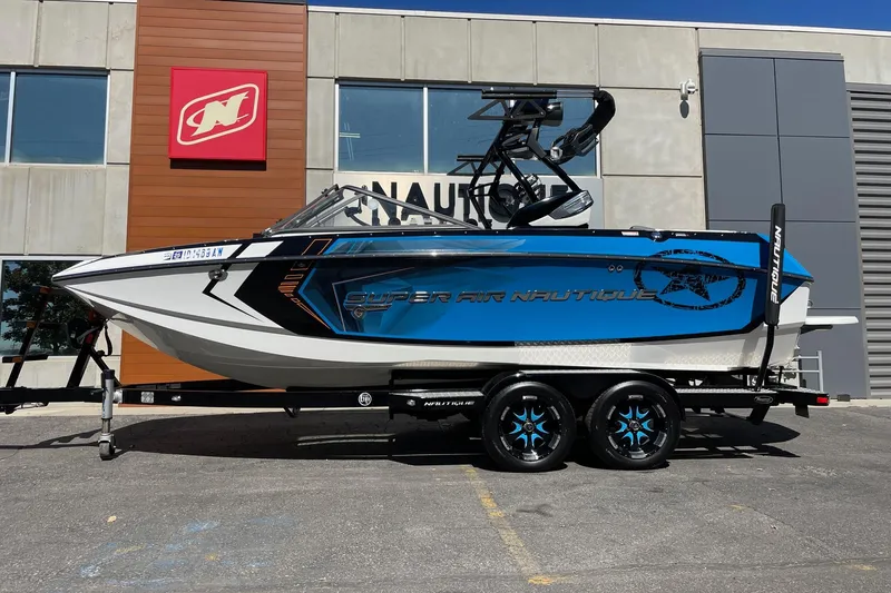 The Image of 2016 Nautique Super Air Nautique G21 boat on trailer outside dealership. - 1
