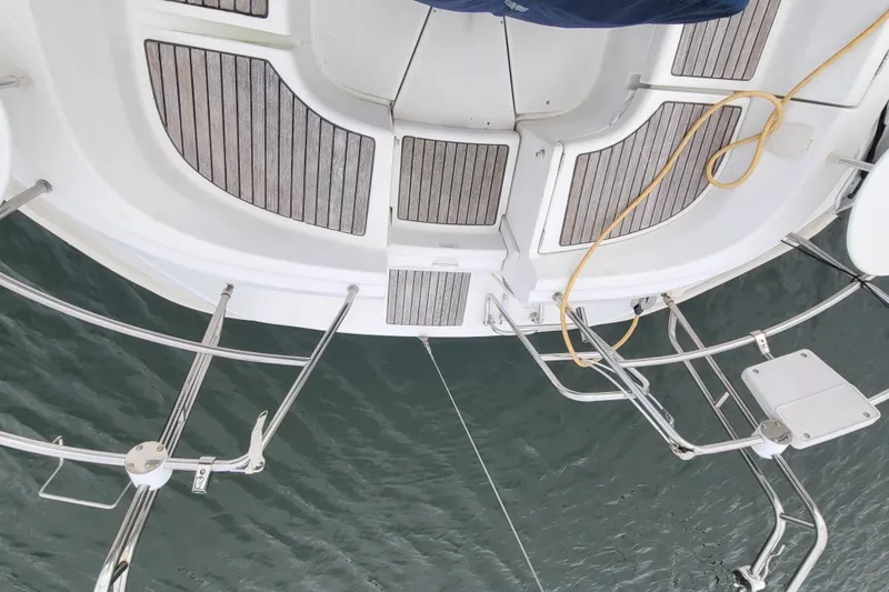 Slide: The Image of Beneteau Oceanis 311 sailboat deck, 2002 model, with teak flooring and metal railings. - 10