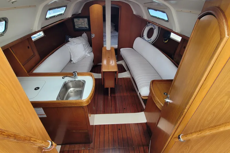 Slide: The Image of Interior of 2002 Beneteau Oceanis 311 sailboat with wood finish and compact kitchen. - 15