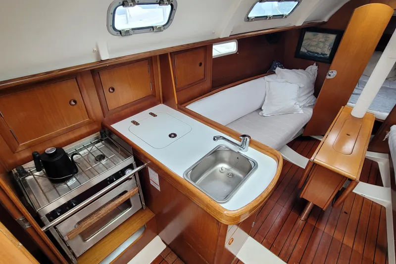 Slide: The Image of Interior of 2002 Beneteau Oceanis 311 sailboat with kitchenette and seating area. - 16