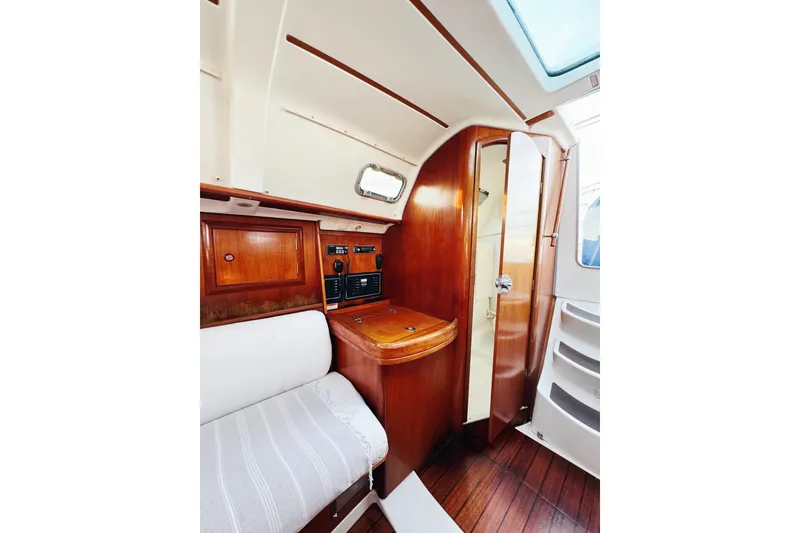 Slide: The Image of Interior of 2002 Beneteau Oceanis 311 sailboat with wooden cabinetry and seating. - 19