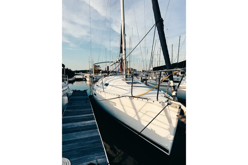 Slide: The Image of 2002 Beneteau Oceanis 311 sailboat docked at marina under clear sky. - 2