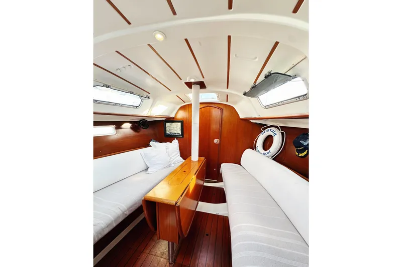 Slide: The Image of 2002 Beneteau Oceanis 311 yacht interior with wooden finish and white seating. - 20