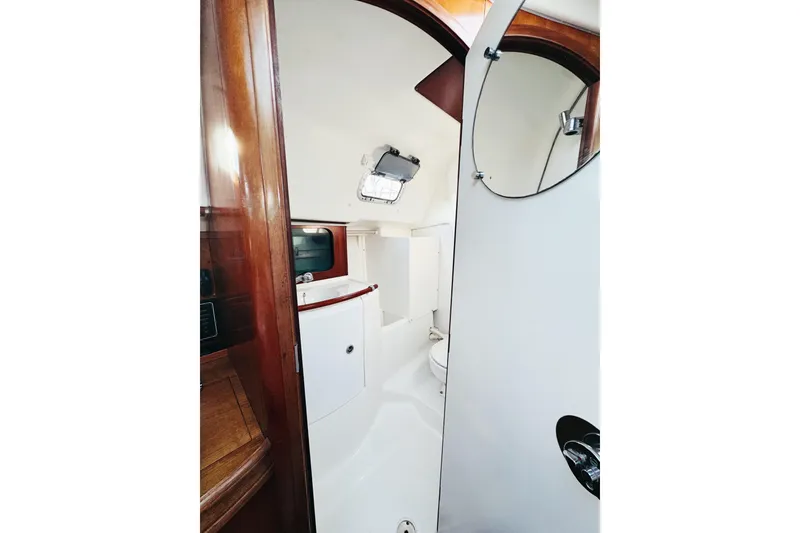 Slide: The Image of Interior view of 2002 Beneteau Oceanis 311 yacht bathroom with wooden accents. - 22